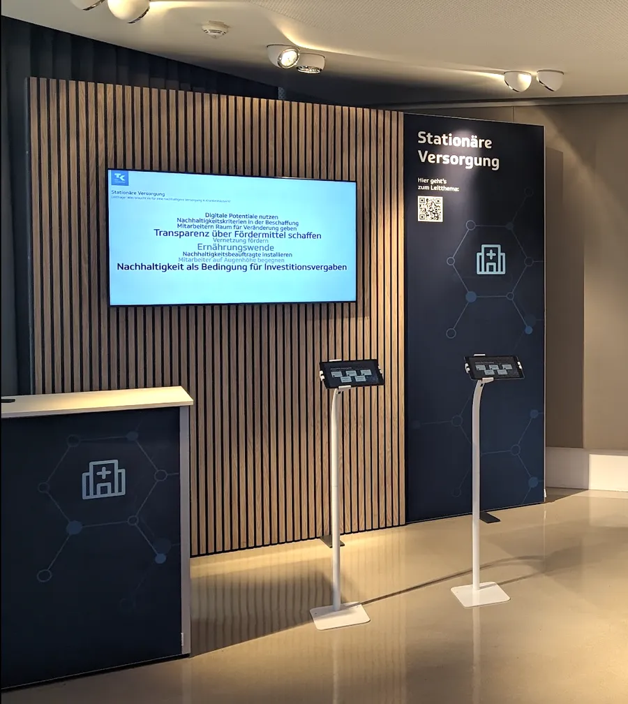 Messestand mit Live-Wortwolke auf dem Screen und zwei iPad-Stelen